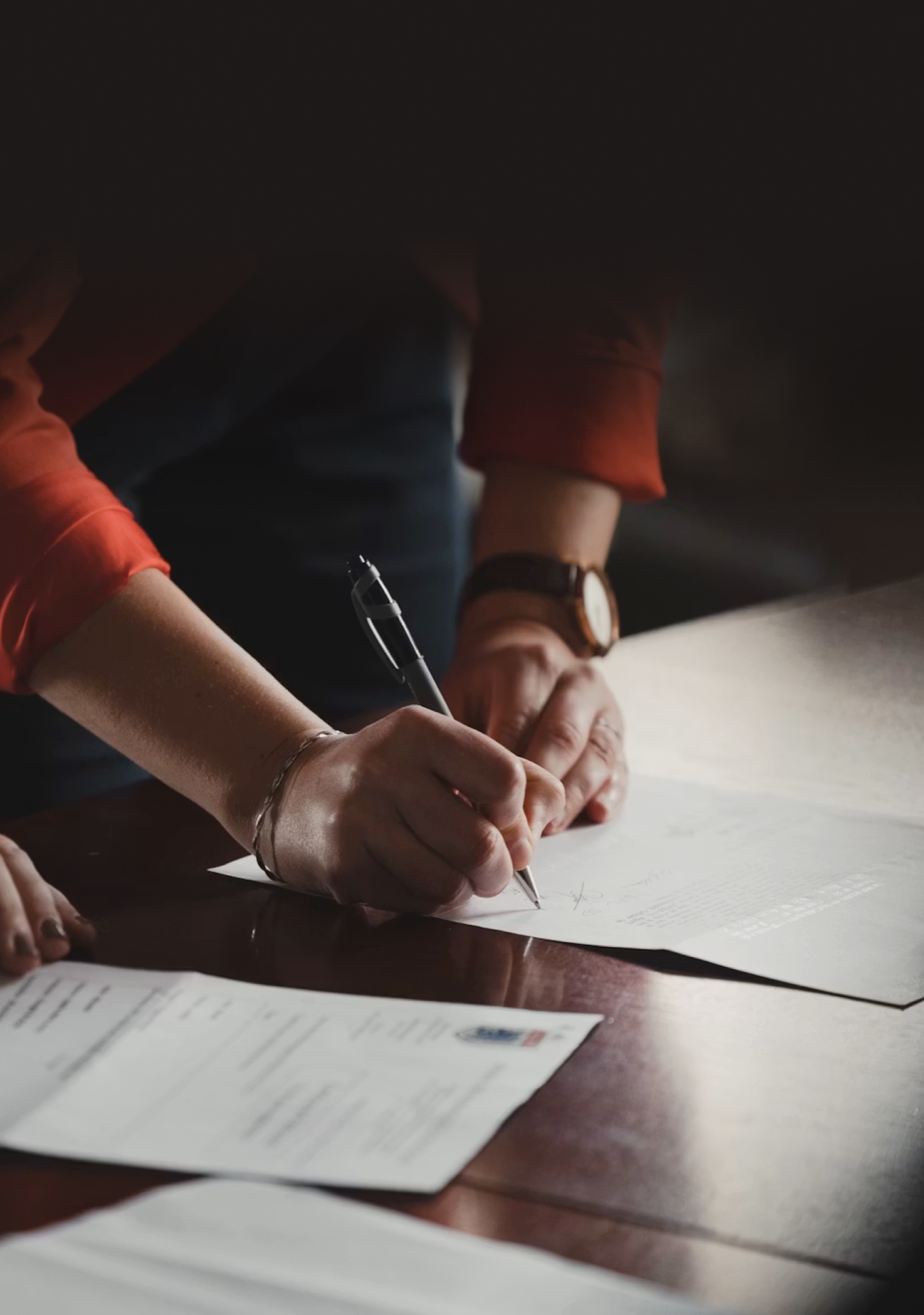 A professional signing documents at a table