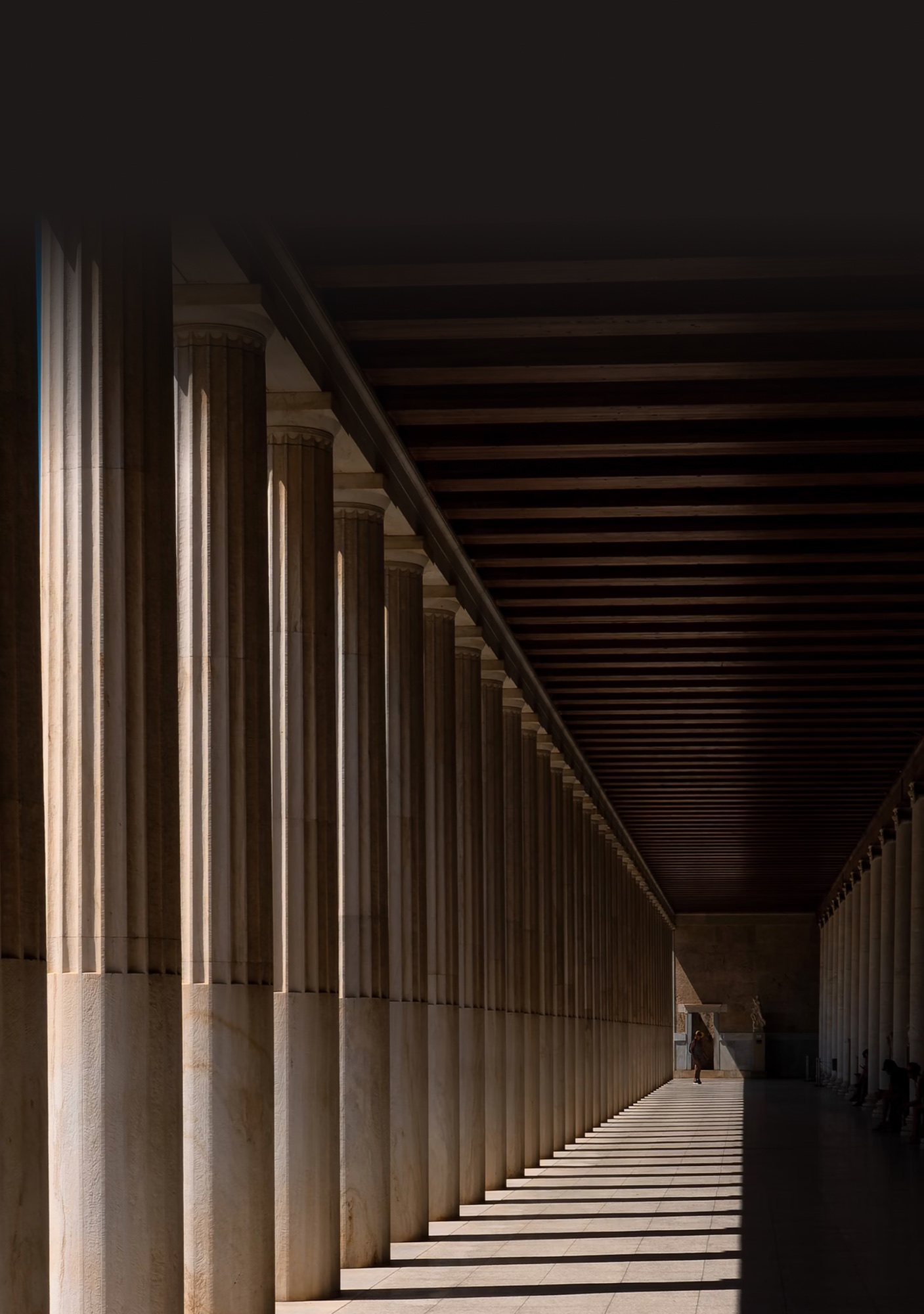 A sunlit colonnade leading through an institutional building